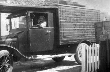 1933 - Piet de Jong achter het stuur van de T-Ford met gesloten laadbak en een rek boven de cabine.